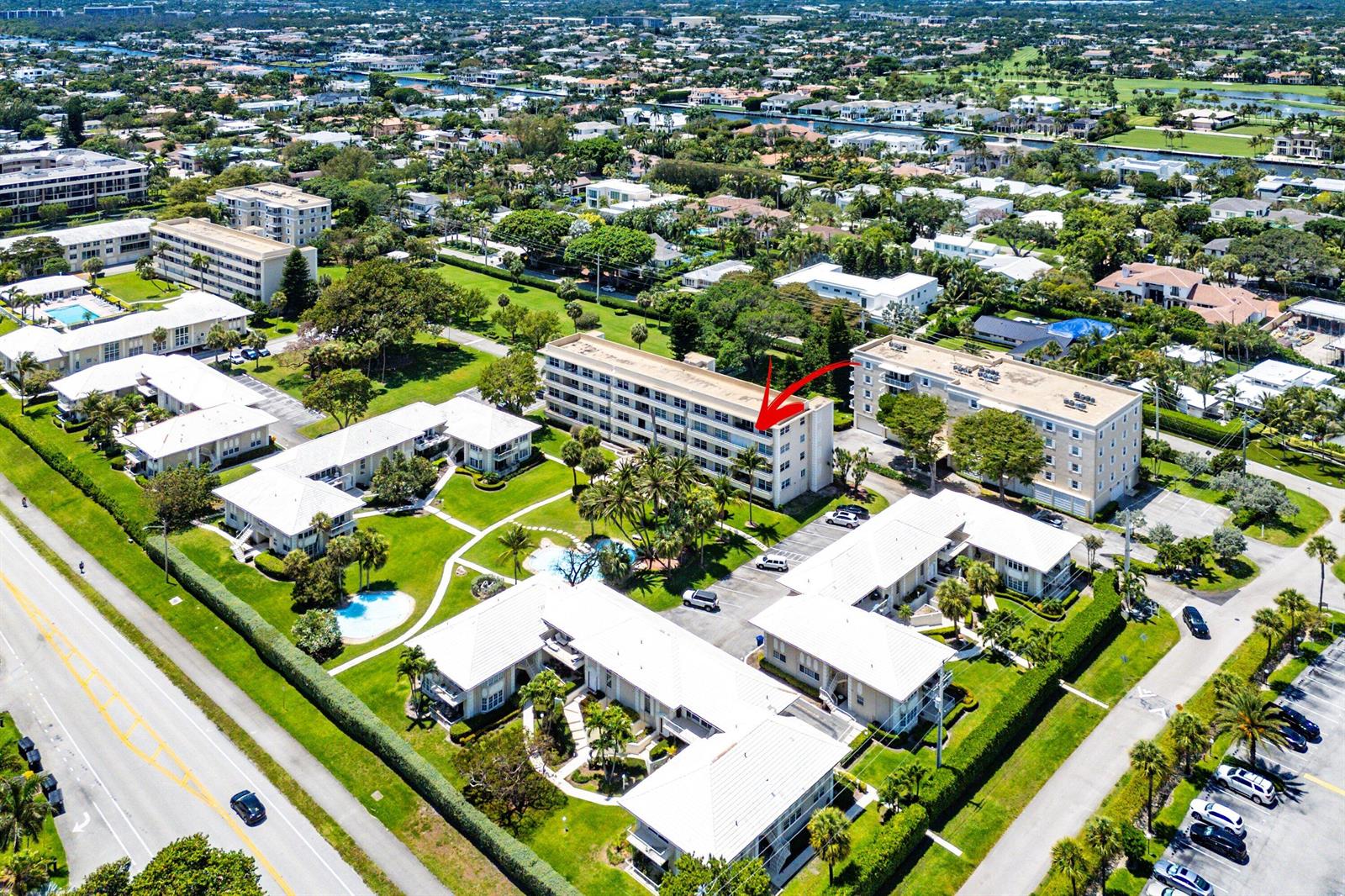 An aerial view shows a multi-story apartment complex surrounded by green lawns and parking lots — 1299 S Ocean Boulevard # R12, Boca Raton FL 33432, BOCA RATON, FL
