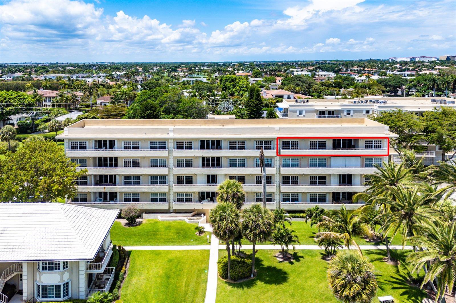 An exterior view of a multi-story apartment building with a highlighted top-floor balcony — 1299 S Ocean Boulevard # R12, Boca Raton FL 33432, BOCA RATON, FL