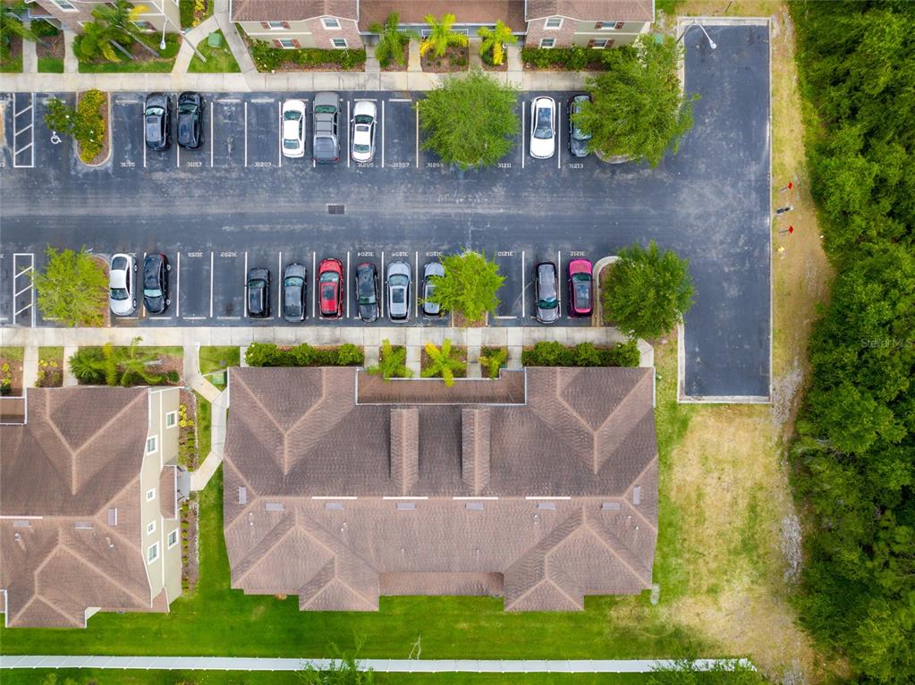 An aerial view shows a residential building with an adjacent parking lot and green space — 31210 GOSSAMER WAY, WESLEY CHAPEL, FL