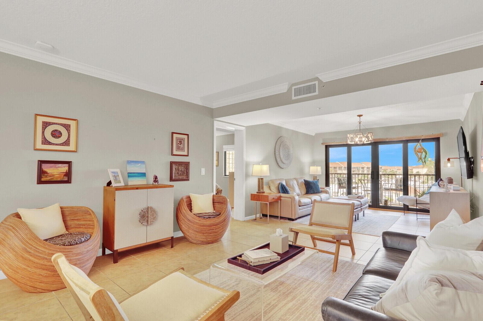 A living room features tile floors, rattan chairs, leather sofas, and a balcony with views — 901 Seafarer Circle # 403, Jupiter FL 33477, JUPITER, FL