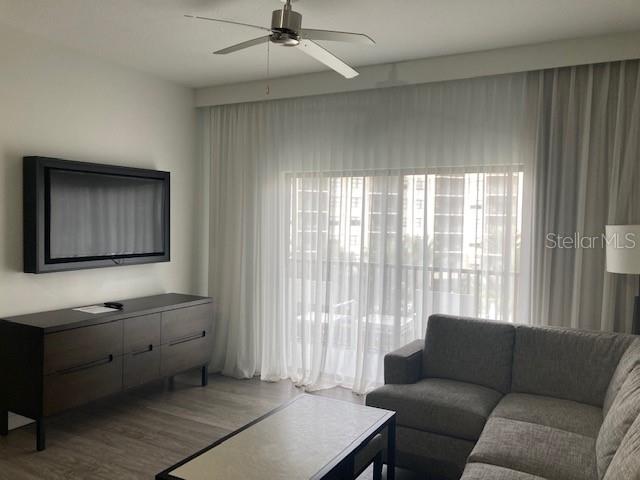 A living room features a wall-mounted television, a dark wood console, and a gray sofa — 14501 GROVE RESORT AVENUE UNIT 3406, WINTER GARDEN, FL