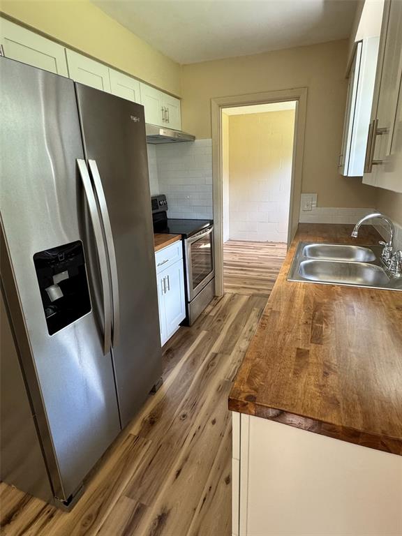 A kitchen with stainless steel appliances, white cabinets, and wood countertops — 128 11TH WAHNETA STREET W, WINTER HAVEN, FL