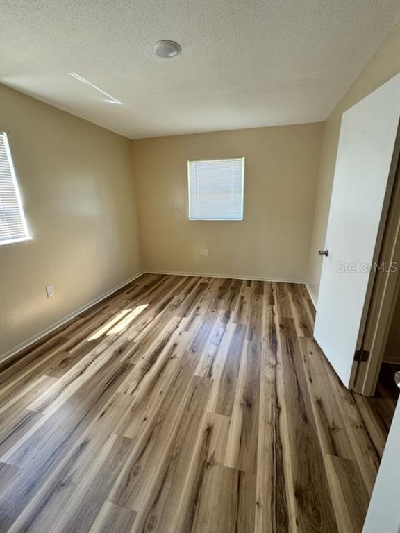 An empty bedroom features light-colored walls, a single window, and wood-look laminate flooring — 128 11TH WAHNETA STREET W, WINTER HAVEN, FL