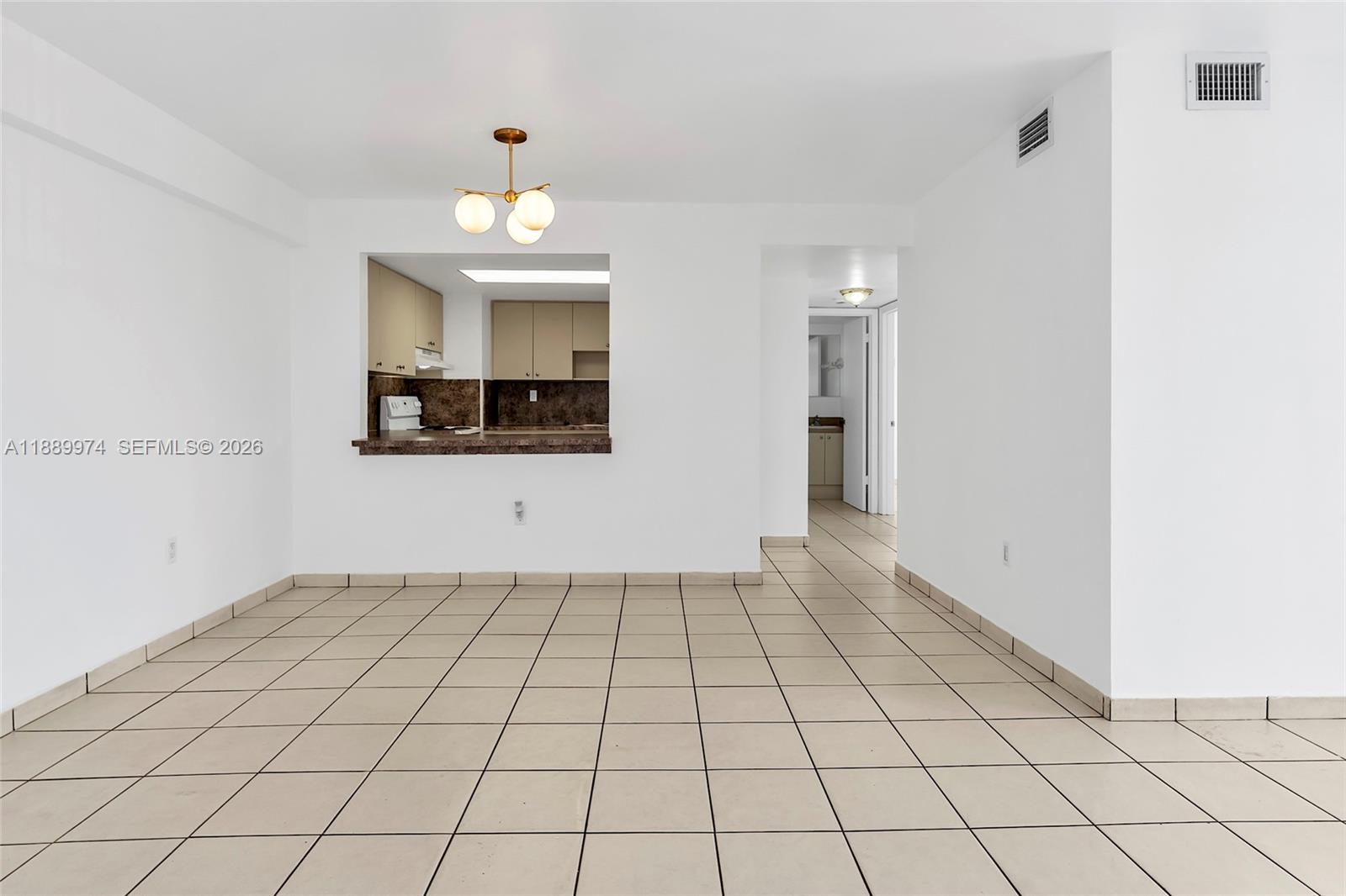 This room features white walls, beige tile flooring, and a kitchen pass-through window — 3945 SW 89th Ave # 201, Miami FL 33165, MIAMI, FL