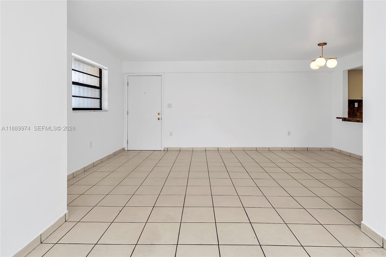 An empty room features white walls, a tiled floor, a window, and a doorway — 3945 SW 89th Ave # 201, Miami FL 33165, MIAMI, FL