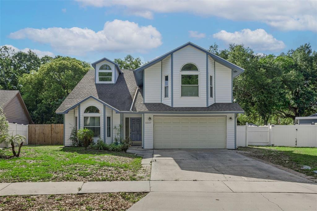 A two-story house with white siding, a two-car garage, and a concrete driveway — 3237 MONTROSE CIRCLE, PALM HARBOR, FL