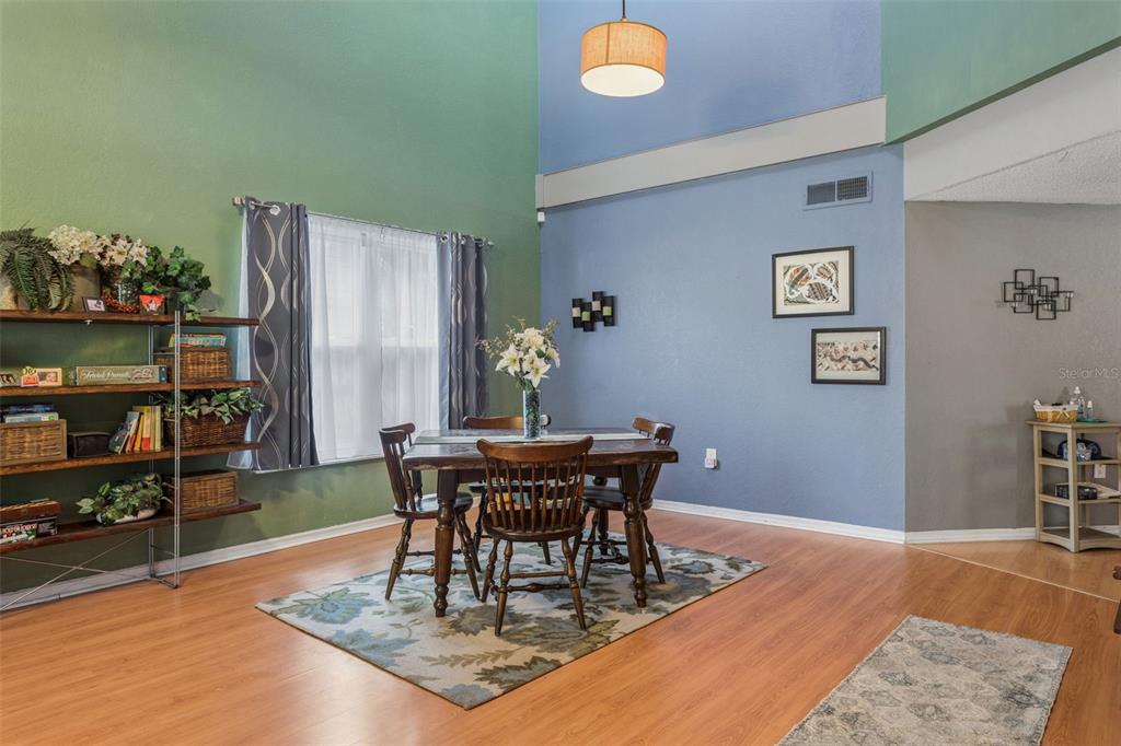 A dining room features a wooden table, chairs, a rug, and two-toned painted walls — 3237 MONTROSE CIRCLE, PALM HARBOR, FL
