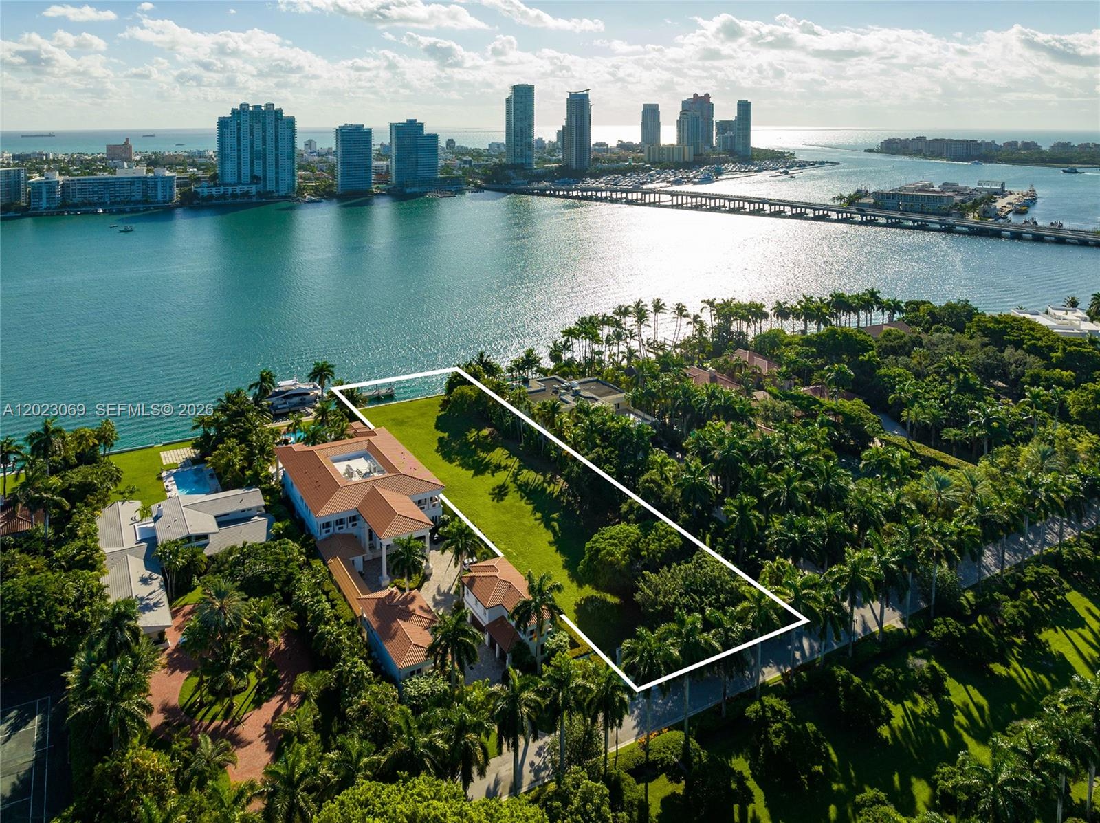 An aerial view shows a large waterfront estate with a sprawling lawn and lush landscaping — 36 Star Island Dr, Miami Beach FL 33139, MIAMI BEACH, FL