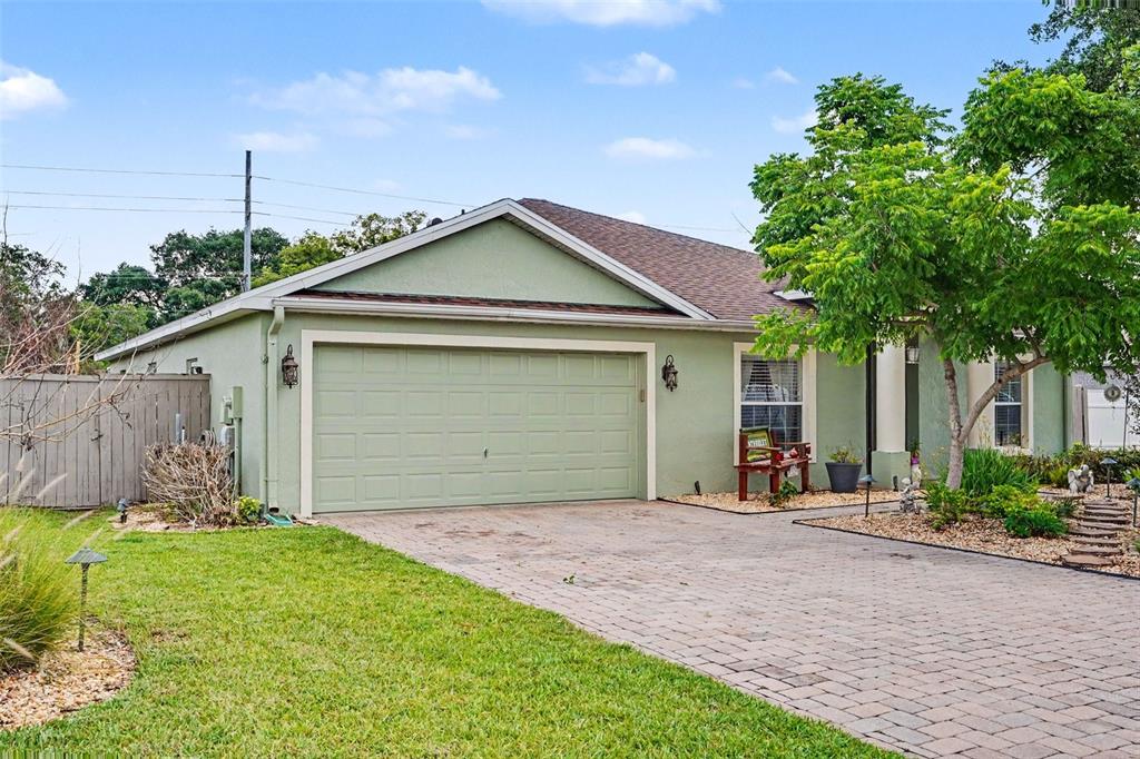 A light green house with a two-car garage and a paved driveway — 423 MAJESTIC GARDENS BLVD, WINTER HAVEN, FL