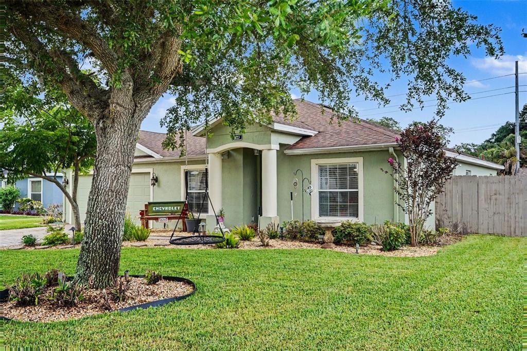 A single-story house with a green exterior, a front porch, and a large shade tree — 423 MAJESTIC GARDENS BLVD, WINTER HAVEN, FL