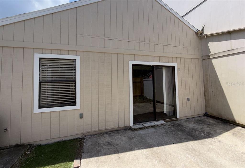 A beige exterior wall features a window with blinds and a sliding glass door — 96 TOMOKA MEADOWS BOULEVARD, ORMOND BEACH, FL
