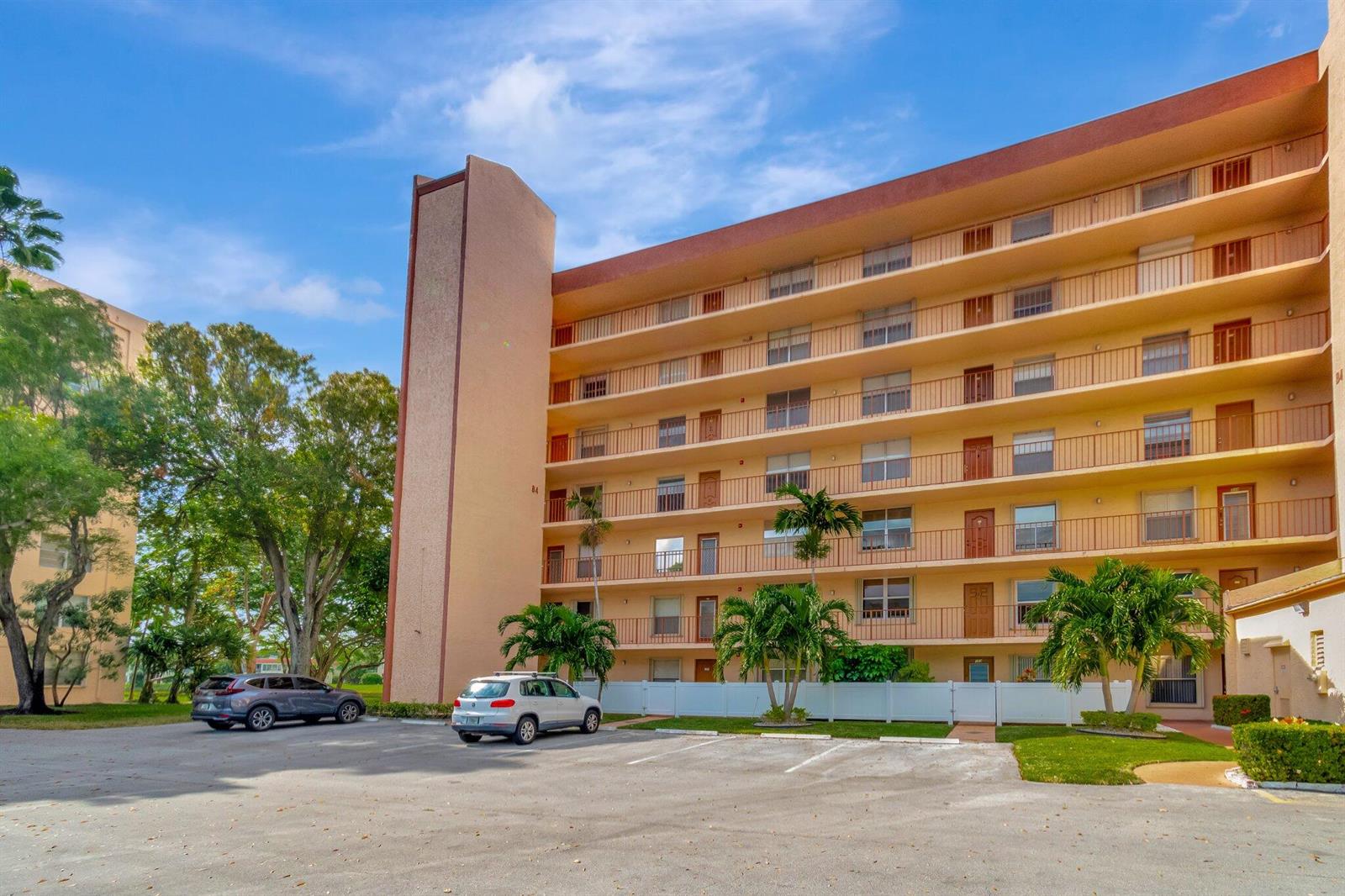 A multi-story apartment building with balconies and a parking lot in front — 14623 Bonaire Boulevard # 502, Delray Beach FL 33446, DELRAY BEACH, FL