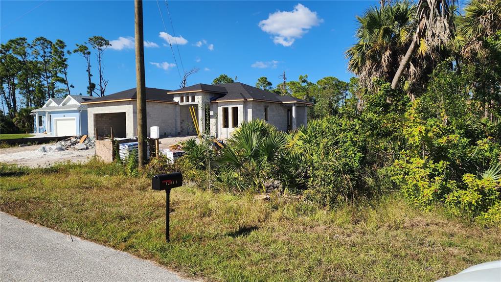 A partially constructed single-story house with a dark roof stands on a grassy lot — 12062 COLEMAN AVENUE, PORT CHARLOTTE, FL