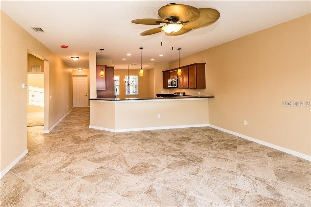 An open-concept kitchen with a breakfast bar, tile flooring, and a ceiling fan — 3948 SAN ROCCO DRIVE UNIT 112, PUNTA GORDA, FL