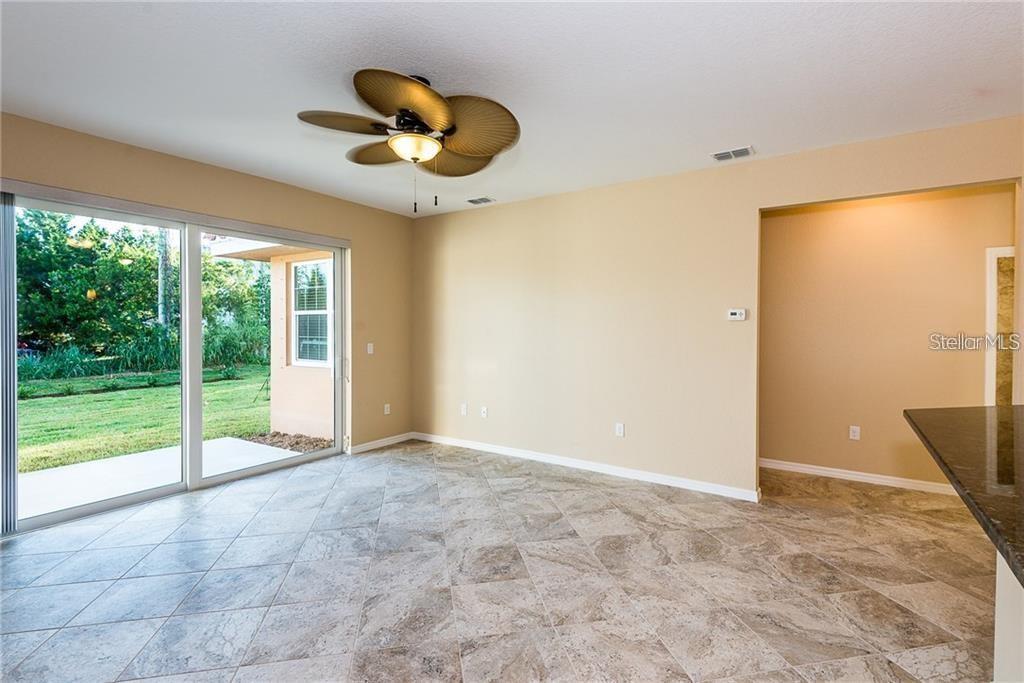 A dining area with tile flooring, a ceiling fan, and sliding glass doors to a yard — 3948 SAN ROCCO DRIVE UNIT 112, PUNTA GORDA, FL