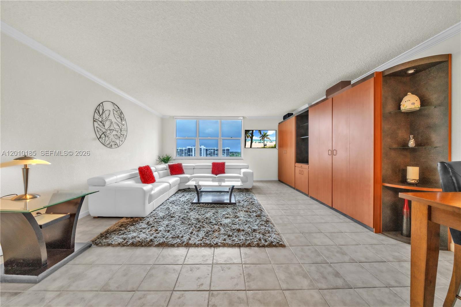 A living room features a white sectional sofa, a shaggy rug, and built-in wooden cabinetry — 2501 S Ocean Dr, Hollywood FL 33019, HOLLYWOOD, FL