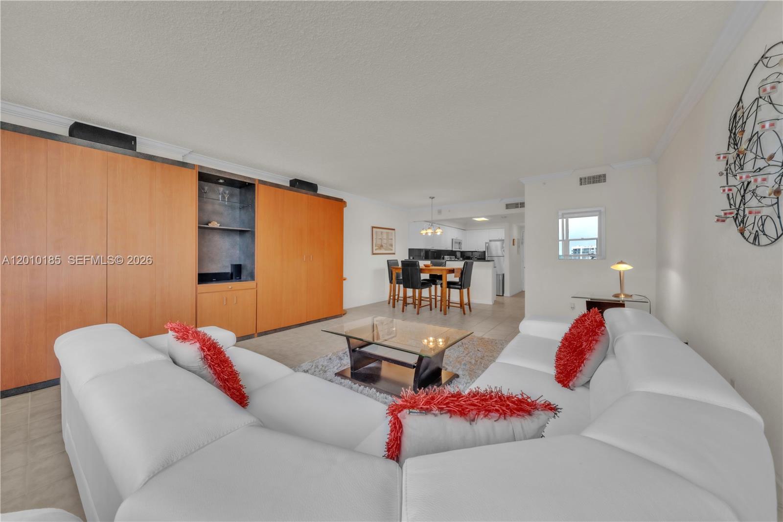A living room with a white sectional sofa, glass coffee table, and wood cabinetry — 2501 S Ocean Dr, Hollywood FL 33019, HOLLYWOOD, FL