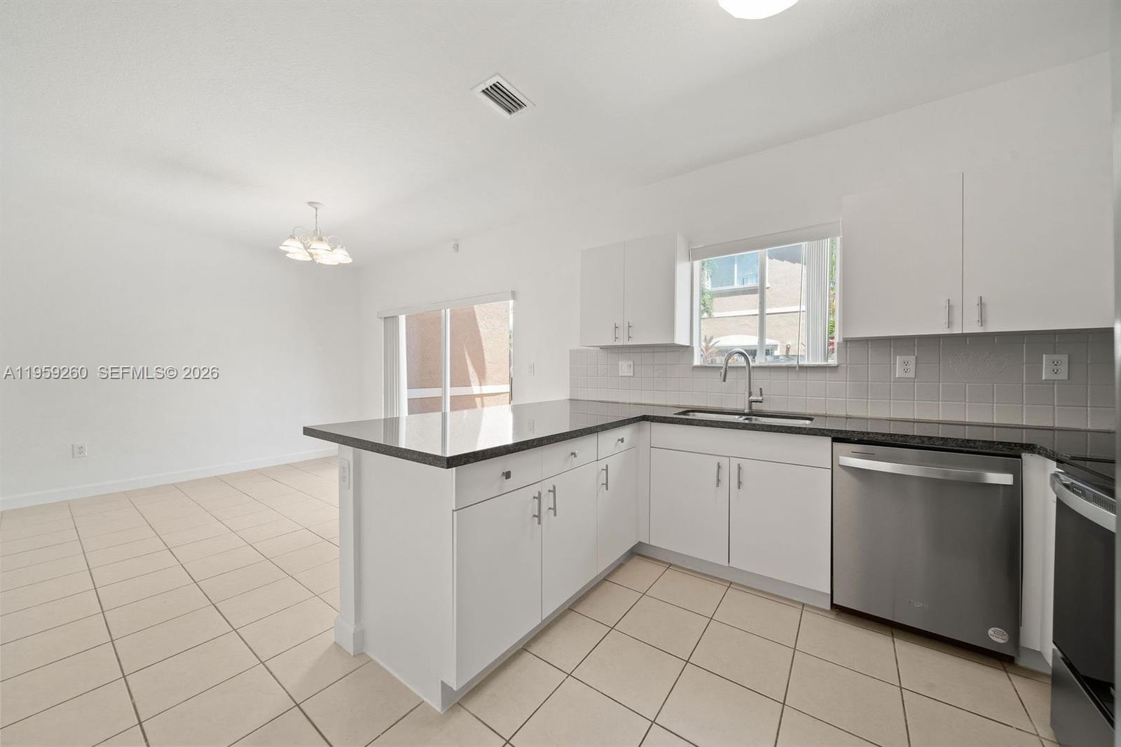 A kitchen features white cabinets, dark countertops, stainless steel appliances, and tile flooring — 21459 SW 86th Pl, Cutler Bay FL 33189, CUTLER BAY, FL