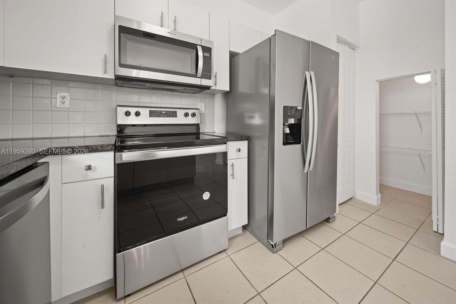 A kitchen features stainless steel appliances, white cabinets, dark countertops, and a walk-in pantry — 21459 SW 86th Pl, Cutler Bay FL 33189, CUTLER BAY, FL