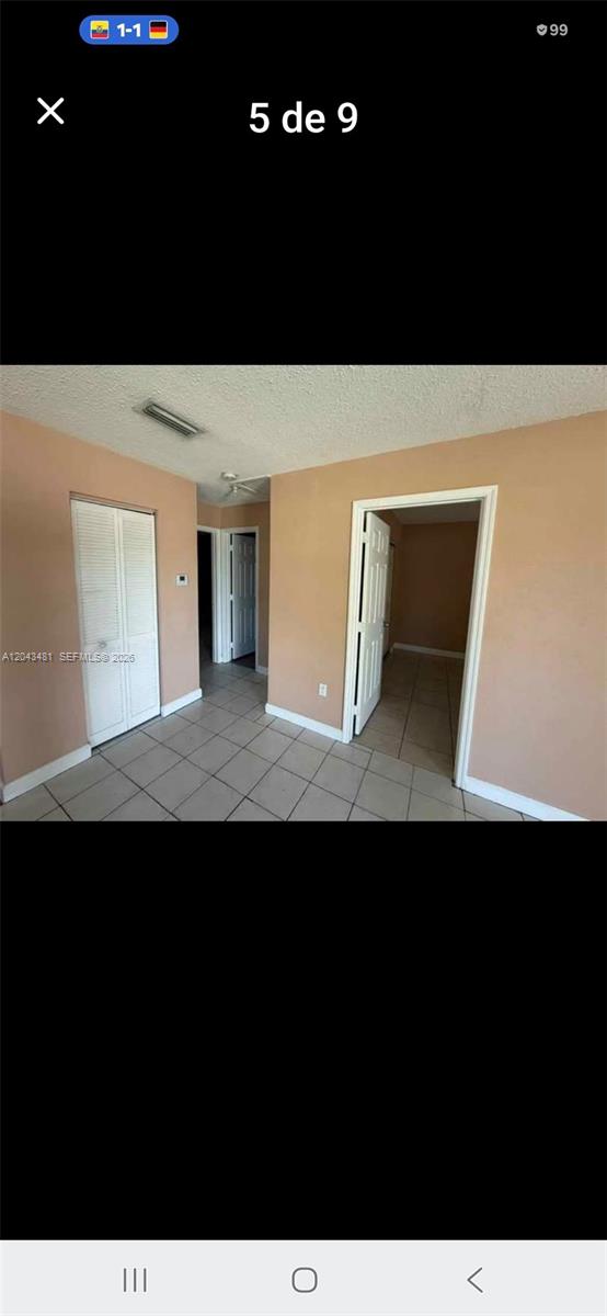 An interior view shows a tiled hallway with white doors and peach-colored walls — 244 NW 14th St # 1, Pompano Beach FL 33060, POMPANO BEACH, FL