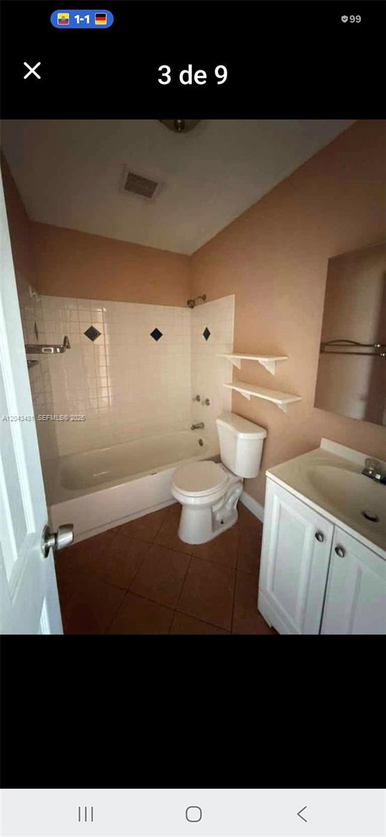 A bathroom features a white bathtub, a toilet, a vanity, and wall-mounted shelves — 244 NW 14th St # 1, Pompano Beach FL 33060, POMPANO BEACH, FL