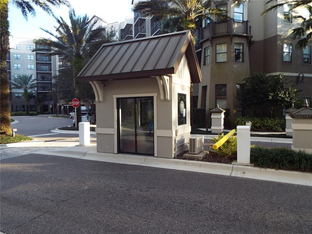 A small guard shack with a metal roof sits at a gated community entrance — 14501 GROVE RESORT AVENUE UNIT 3538, WINTER GARDEN, FL