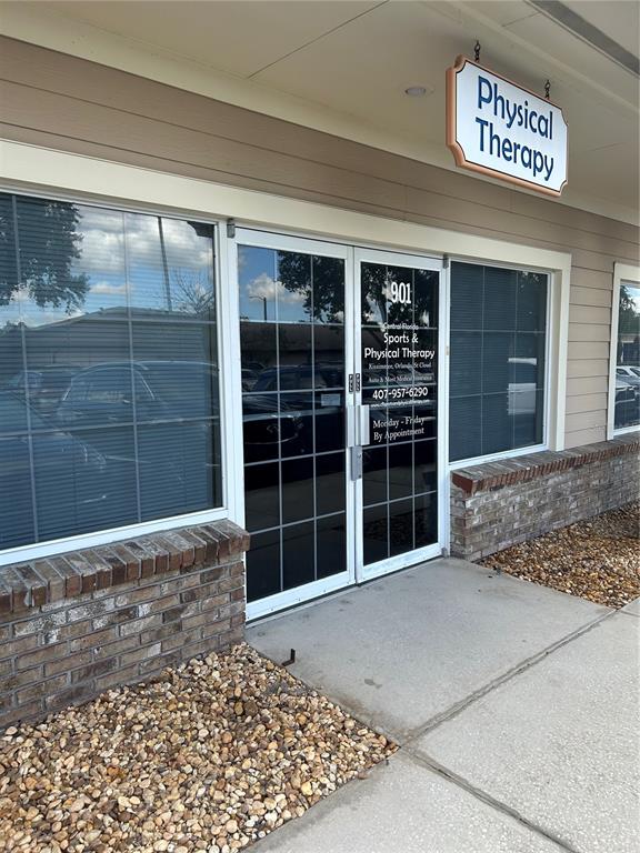 The exterior of a commercial building features a glass double door entrance and signage — 901 N CENTRAL AVENUE, KISSIMMEE, FL