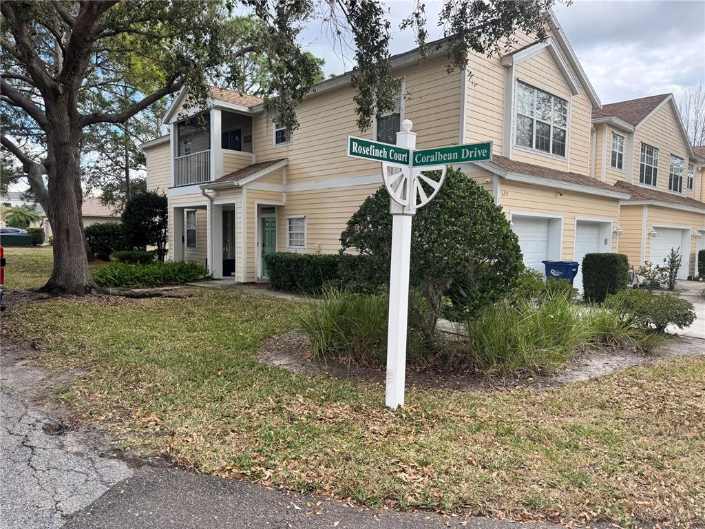 A two-story yellow building stands near a street sign at the intersection of two roads — 6315 ROSEFINCH COURT UNIT 101, LAKEWOOD RANCH, FL