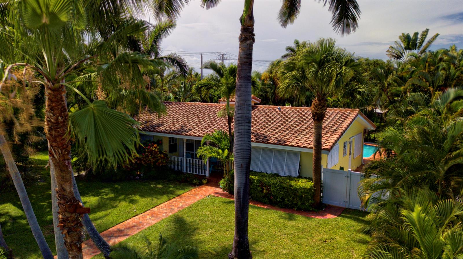An aerial view of a yellow house with a tiled roof surrounded by palm trees — 700 NE 26th Avenue, Pompano Beach FL 33062, POMPANO BEACH, FL