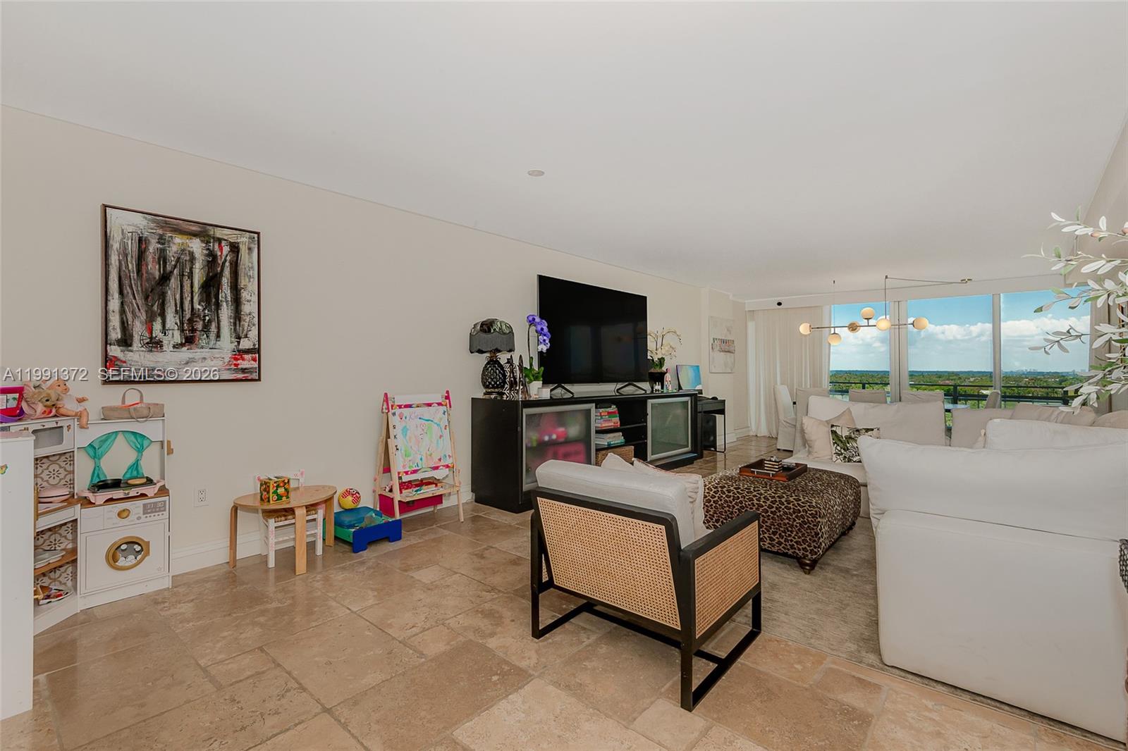 A living room features tile flooring, a large television, and a children's play area — 600 Grapetree Dr, Key Biscayne FL 33149, KEY BISCAYNE, FL