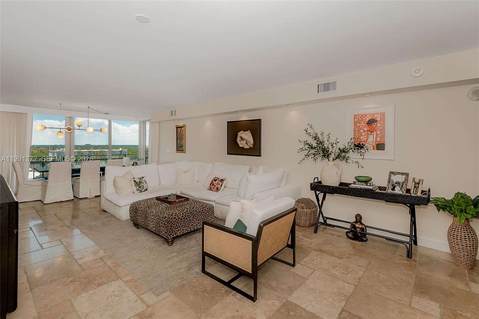 A living room features a white sectional sofa, leopard-print ottoman, and tile flooring — 600 Grapetree Dr, Key Biscayne FL 33149, KEY BISCAYNE, FL