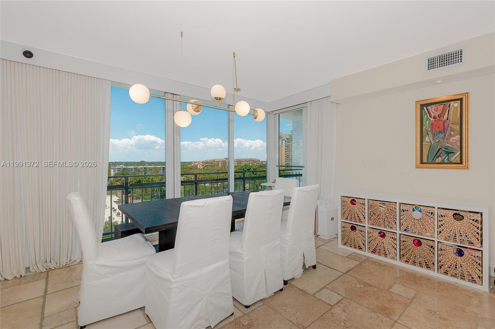A dining room features a dark table, white slipcovered chairs, and a large window view — 600 Grapetree Dr, Key Biscayne FL 33149, KEY BISCAYNE, FL