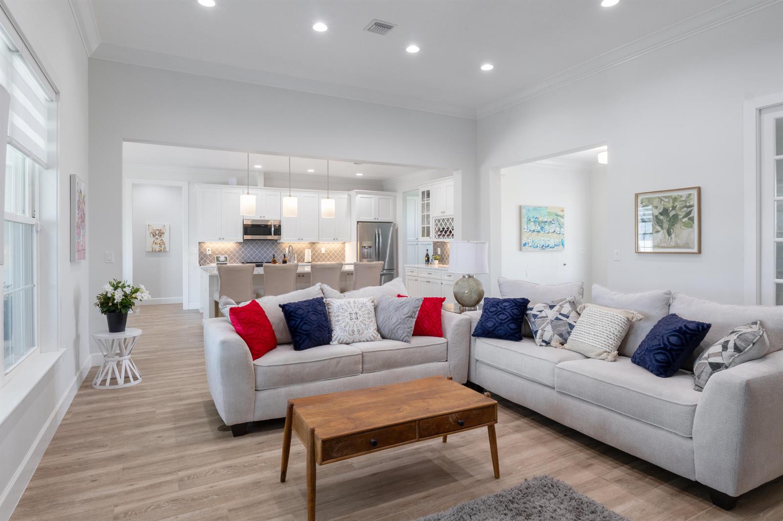 A bright living room with light-colored sofas, a wooden coffee table, and an open kitchen — 6612 SE 26th Trail, Okeechobee FL 34974, OKEECHOBEE, FL