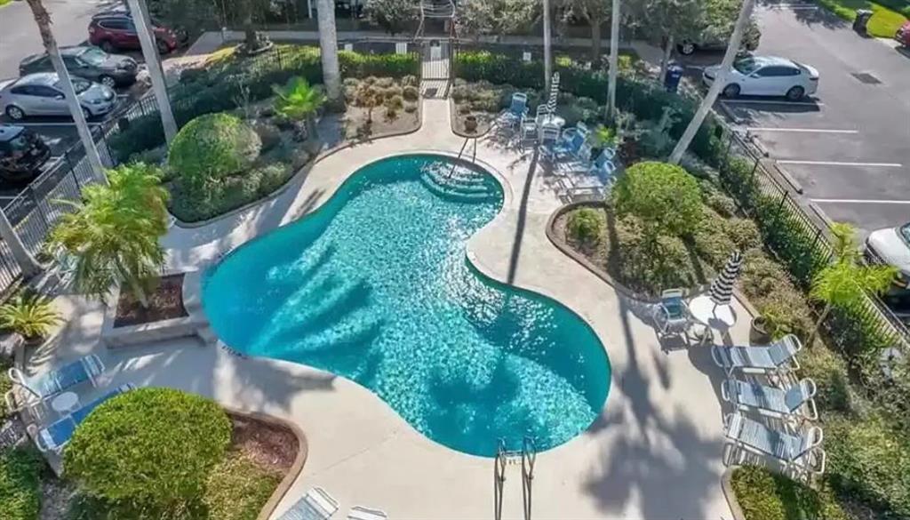An aerial view shows a kidney-shaped swimming pool surrounded by lounge chairs and landscaping — 8013 BOONE DRIVE, LARGO, FL