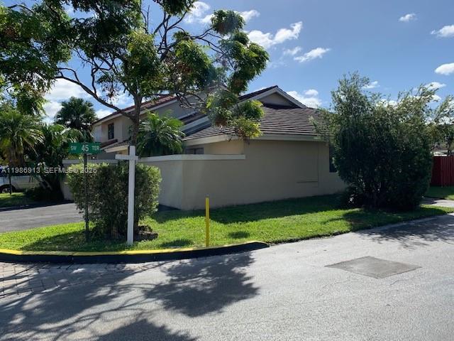 A beige house with a dark shingled roof sits on a corner lot with landscaping — 4526 SW 143rd Ct W # 0, Miami FL 33175, MIAMI, FL