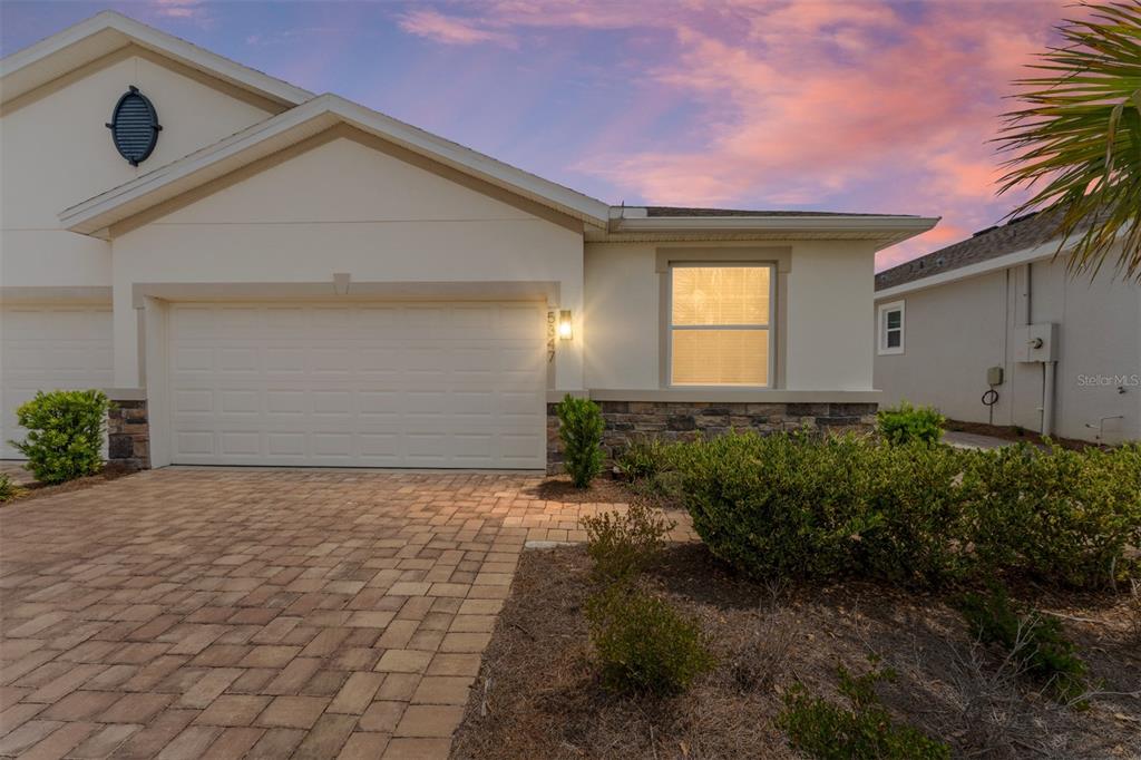 A single-story house exterior features a paved driveway, a two-car garage, and stone accents — 5347 NW 46TH LANE ROAD, OCALA, FL