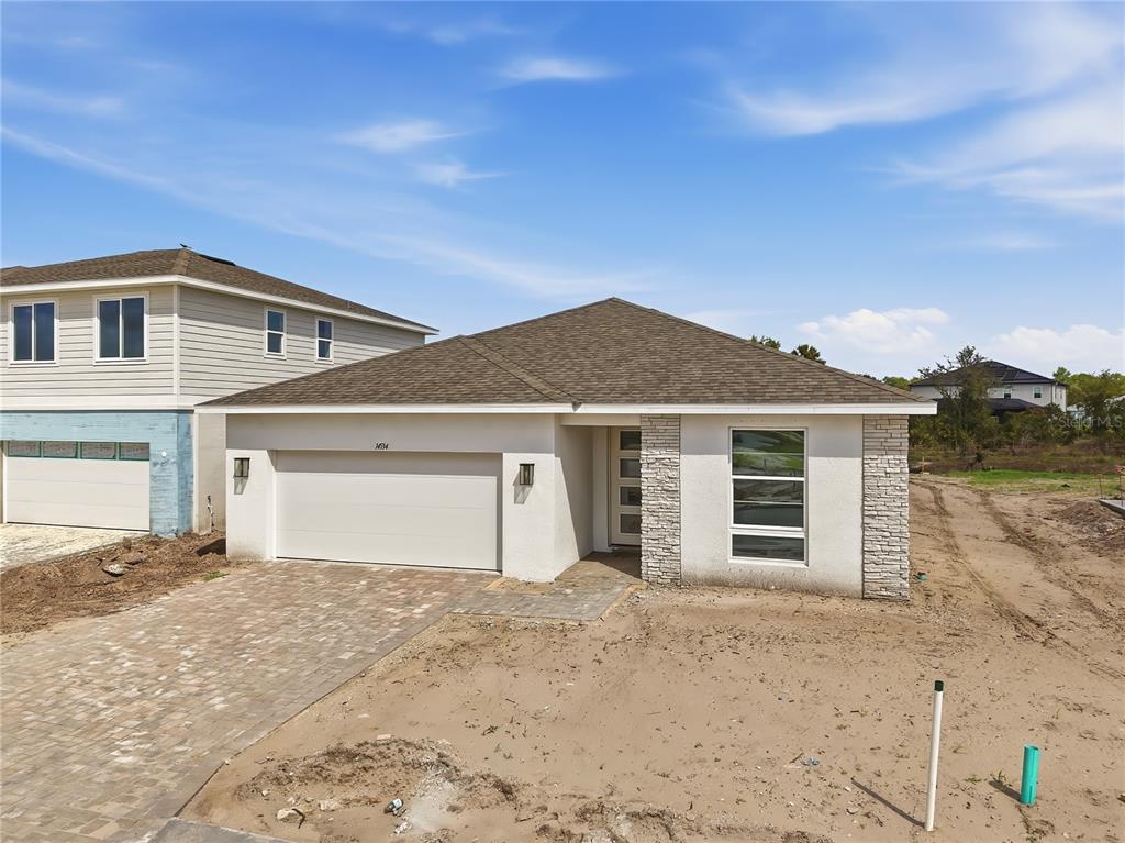 A single-story house with a white stucco exterior, stone accents, and a paved driveway — 14534 BANKS COURT, PARRISH, FL