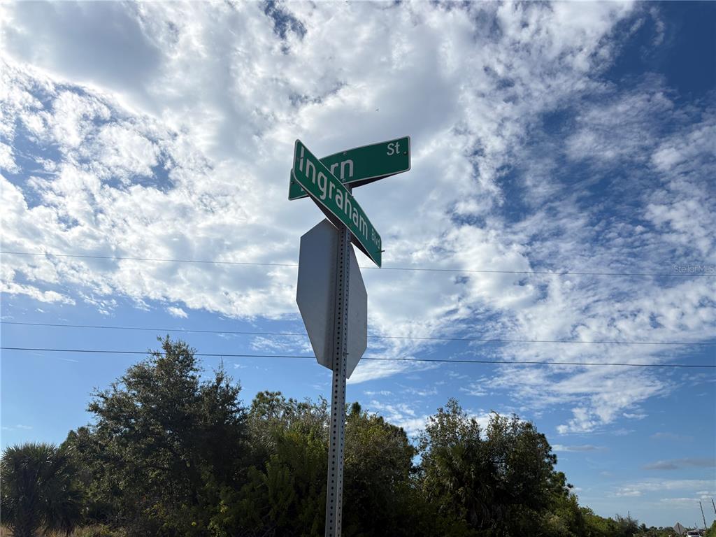 A street sign for Ingraham Blvd and another street stands against a cloudy blue sky — 14251 INGRAHAM BOULEVARD, PORT CHARLOTTE, FL