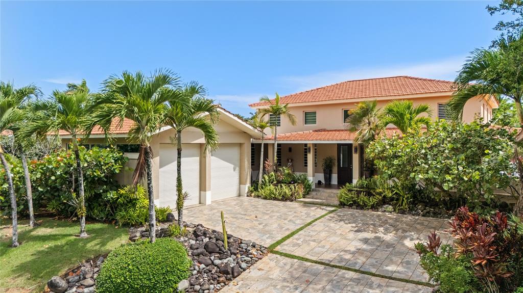 A two-story house with a tiled roof, two-car garage, and a stone-paved driveway — 403 CAMINO DE LOS JOBANES, DORADO, PR