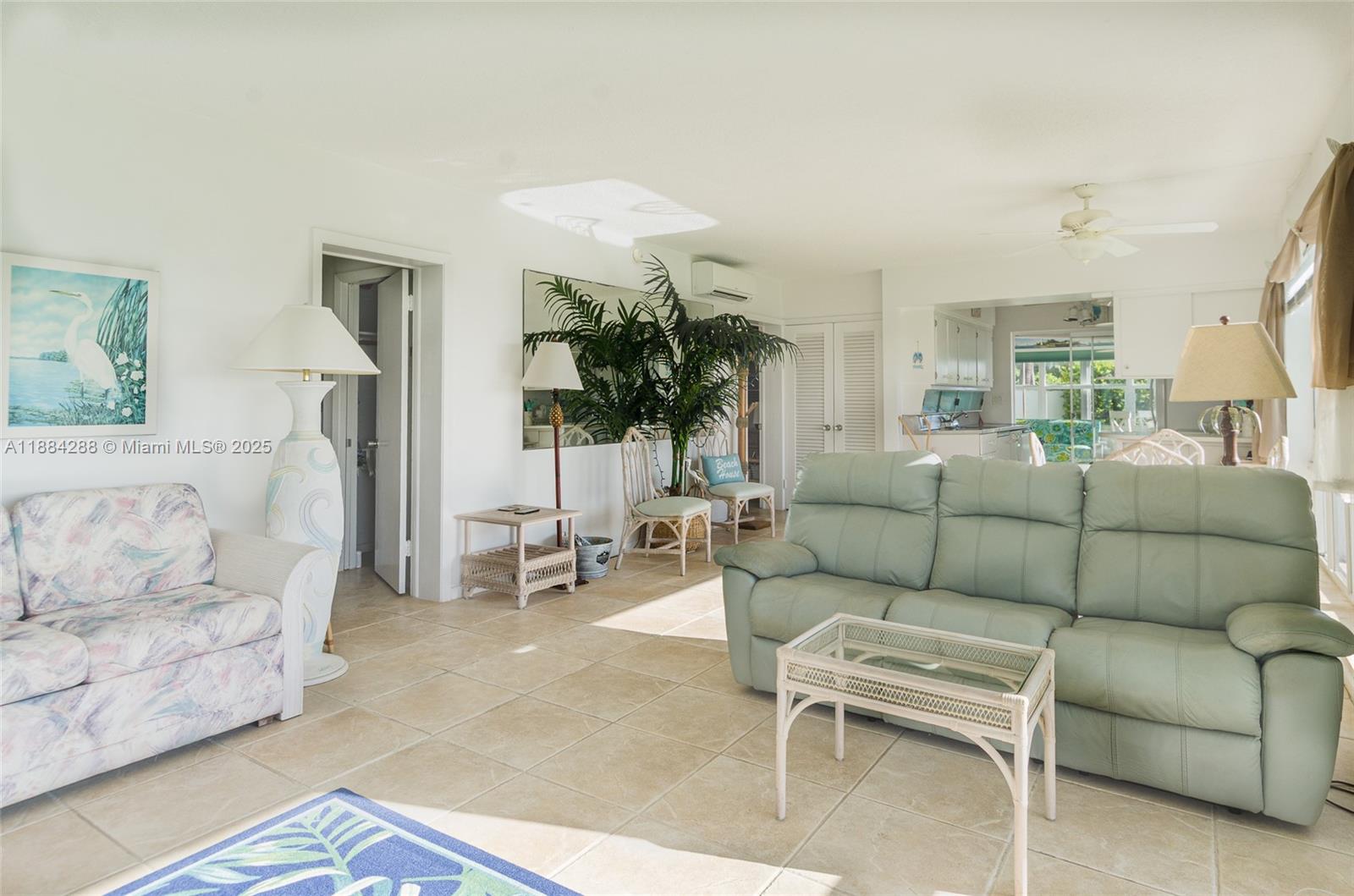 A living room features light tile floors, a green sofa, and a patterned armchair — 1470 S Ocean Blvd # 1201, Pompano Beach FL 33062, POMPANO BEACH, FL