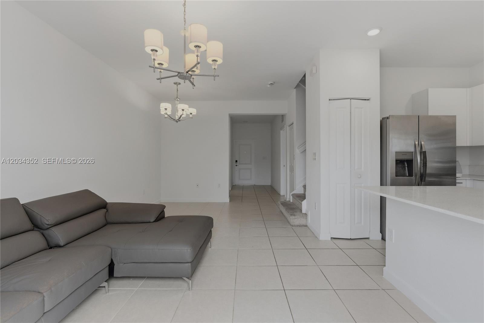A living room with tile floors, a gray sectional sofa, and a chandelier — 16314 SW 291 ST # 16314, Miami FL 33033, MIAMI, FL