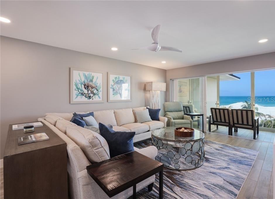 A living room with a sectional sofa, circular coffee table, and a balcony overlooking the ocean — 2110 BENJAMIN FRANKLIN DRIVE UNIT 503SEA, SARASOTA, FL