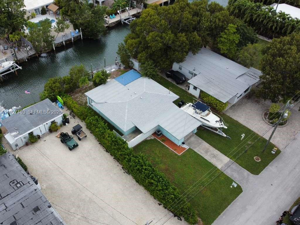 An aerial view shows a house with a boat parked on the lawn near a canal — 1403 Grouper Dr, Marathon FL 33050, MARATHON, FL