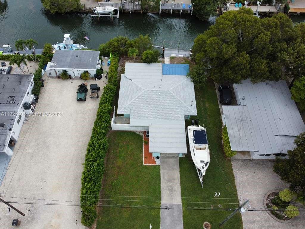 An aerial view shows a house with a boat parked on the lawn near water — 1403 Grouper Dr, Marathon FL 33050, MARATHON, FL
