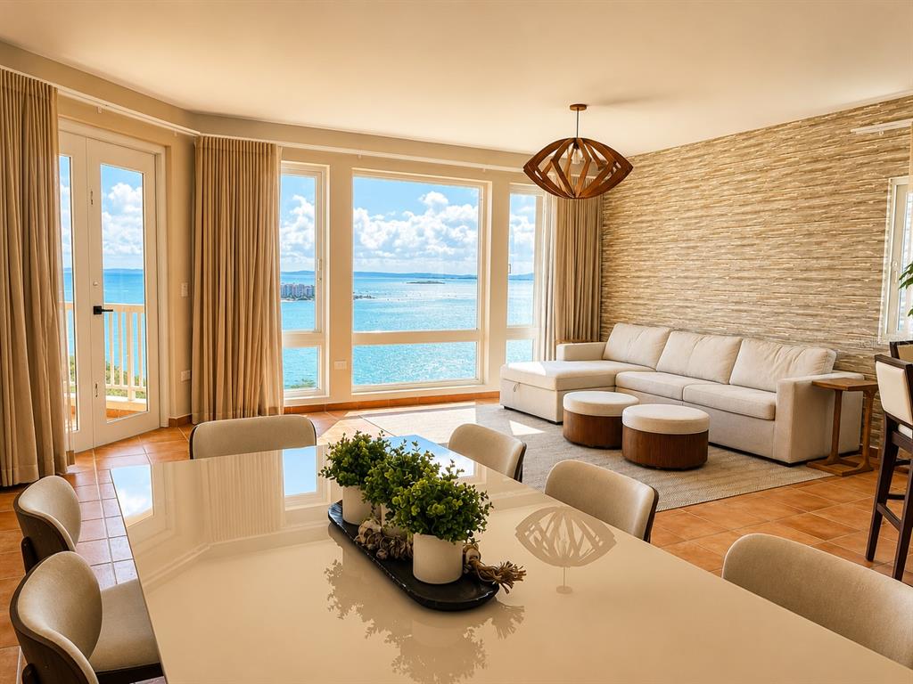 A dining area and living room with a large ocean-view window and stone accent wall — 987 CARR PR UNIT 1, FAJARDO, PR