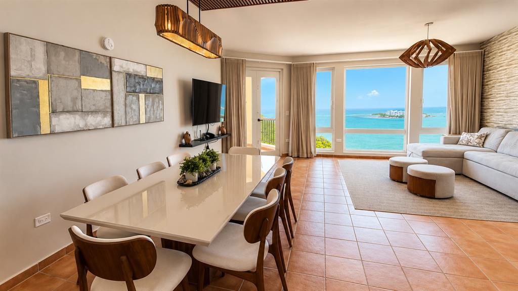 A dining area and living room with tile floors overlook the ocean through large windows — 987 CARR PR UNIT 1, FAJARDO, PR