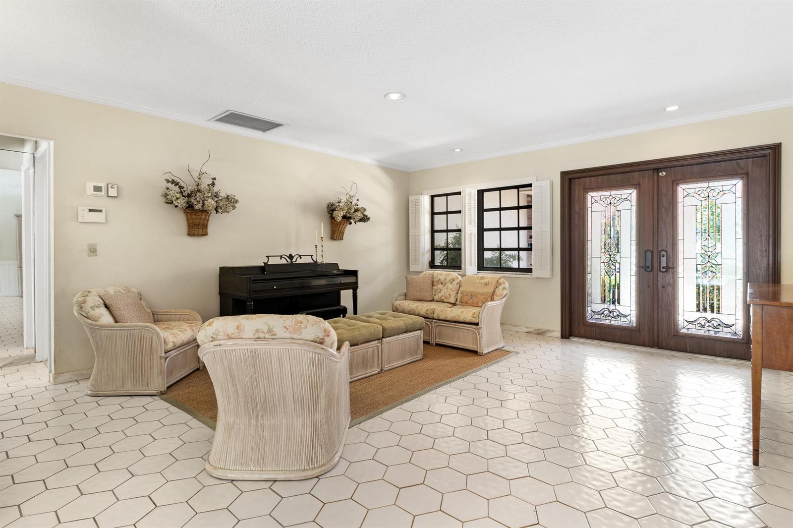A living room features a piano, wicker furniture, and white hexagonal floor tiles — 1350 W Terra Mar Drive, Pompano Beach FL 33062, POMPANO BEACH, FL