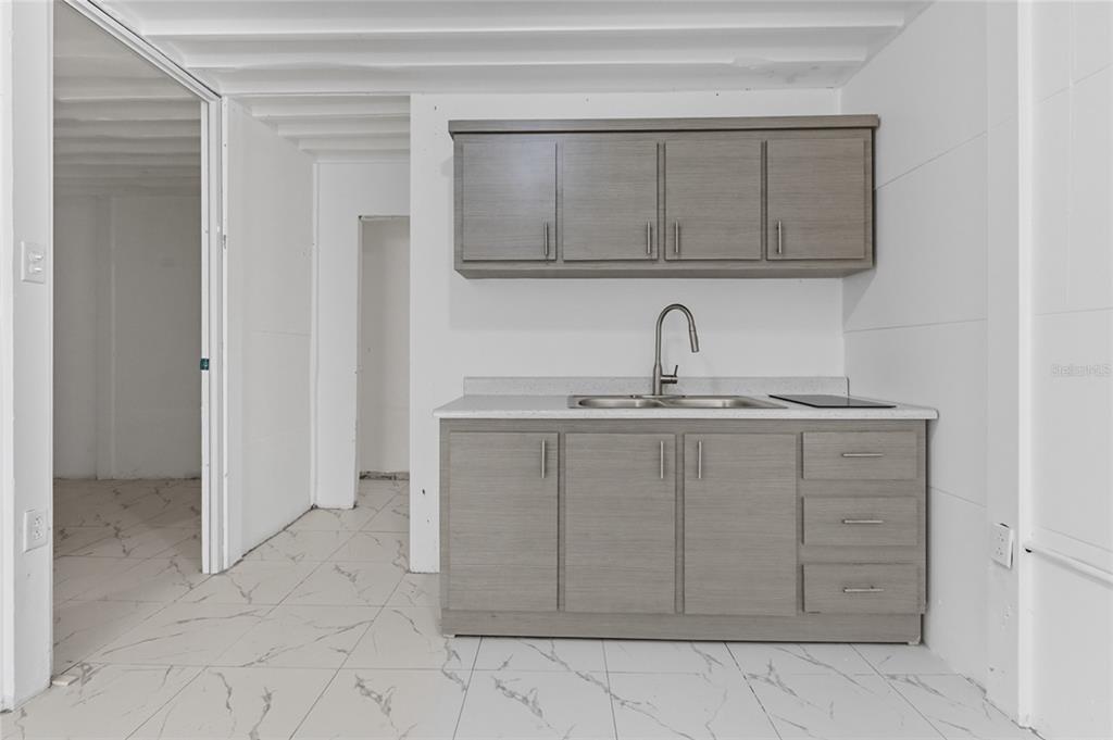 A small kitchenette features gray cabinets, a double-basin sink, and white marble-patterned tile flooring — 36 RAMON B LOPEZ STREET, SAN JUAN, PR