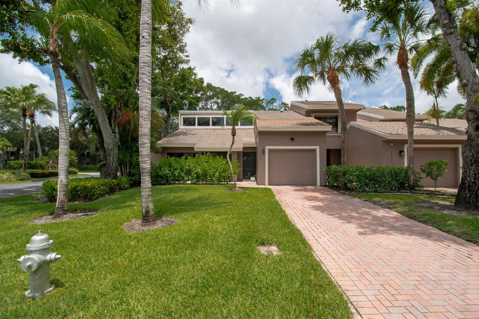 A two-story townhouse with a brick driveway, attached garage, and palm trees in the front yard — 6602 Thornhill Court, Boca Raton FL 33433, BOCA RATON, FL