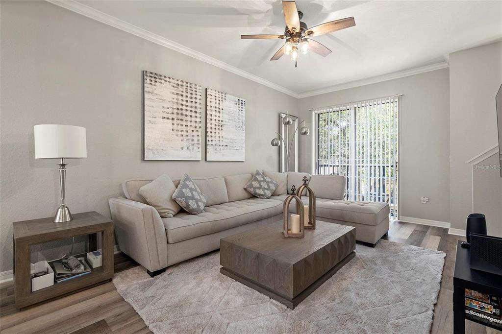 A living room features a beige sectional sofa, a wooden coffee table, and sliding glass doors — 126 BEACH HAVEN LANE UNIT 126, TAMPA, FL
